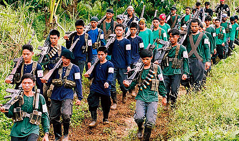 Communist rebels march during a meeting between government officials and New People's Army in the mountains of Surigao del Sur, southern Philippines, Tuesday, Jan. 6, 2004. Philippine communist rebels have rejected a government proposal to extend the ceasefire until after May 2004 elections but instead the rebels are demanding fees from political candidates raging from US$1,000 up to $30,000. The New People's Army is fighting the longest communist insurgency in Asia. (AP Photo/Froilan Gallardo)